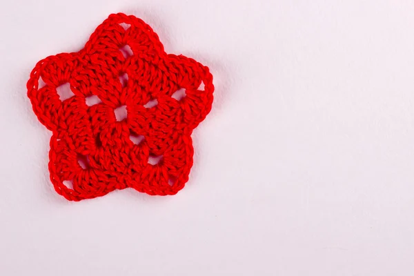 Red star, knitted of red thread on white background — Stock Photo, Image