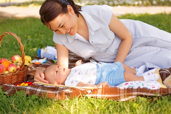 Sevimli küçük oğlu anne yaz Parkta piknik üzerinde ile — Stok fotoğraf