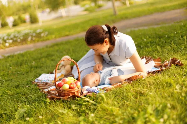 Schattige kleine babyjongen met moeder op picknick in het park van de zomer — Stockfoto
