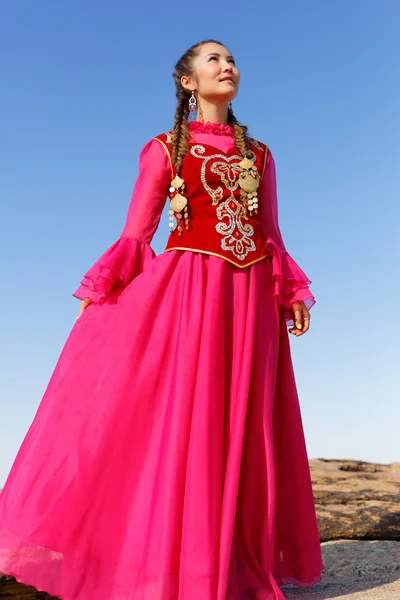 Belle femme kazakh en costume national dans la steppe dansant avec dombyra — Photo