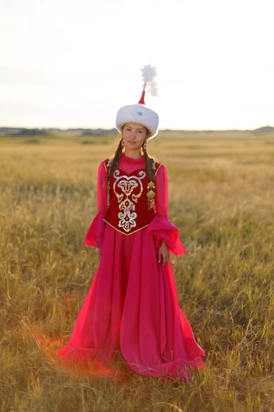Schöne Kasachin in Nationaltracht in der Steppe, die mit Dombyra tanzt — Stockfoto