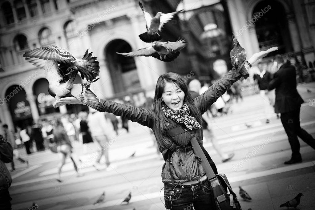 Beautiful and happy kazakh woman playing with doves