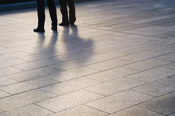 Silhouette Menschen Beine auf Bodenfliese Raum im Freien — Stockfoto