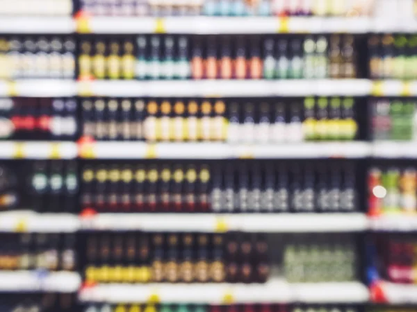 Exposição borrada da prateleira com linha das garrafas no negócio varejo do supermercado — Fotografia de Stock