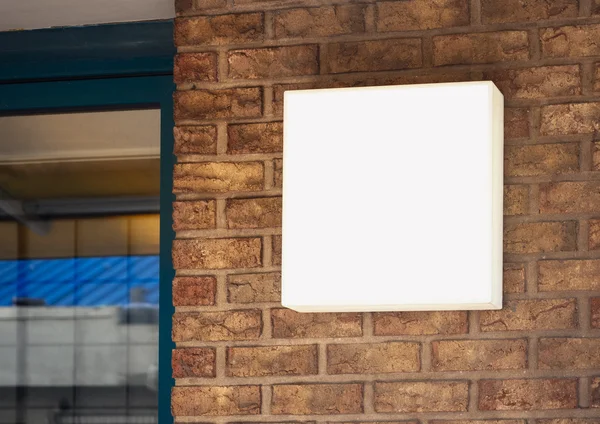 Bewegwijzering Shop bespotten lichtbak teken weergeven op bakstenen muur — Stockfoto
