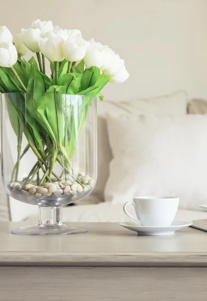 Çiçekler kanepe yastık ev dekorasyonu ile masada kahve fincanı — Stok fotoğraf