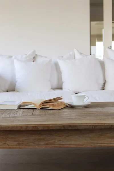 Soggiorno divano caffè e libro su tavolo in legno — Foto Stock