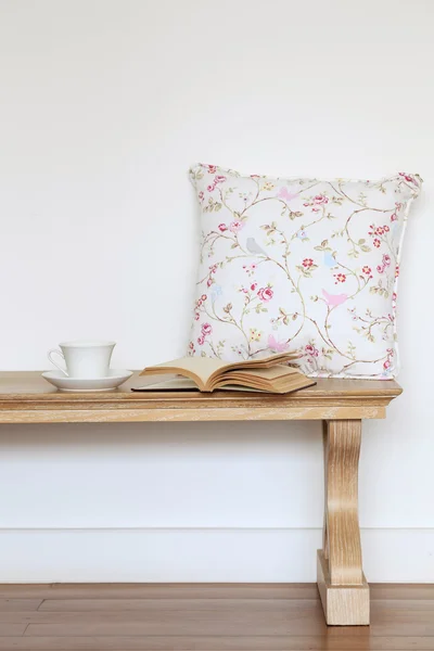 Banco de madera con libro de café y almohada patrón de flores —  Fotos de Stock