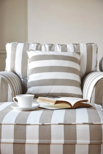 Olohuoneen sohva kahvia ja kirja — kuvapankkivalokuva