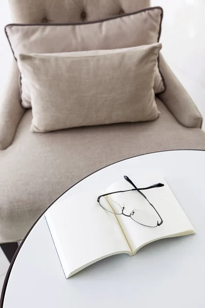 Armchair in living room pillow with book and eyeglasses — Stock Photo, Image