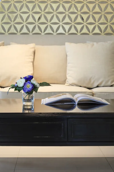 Pokój dzienny sofa poduszki z książki i kwiaty na stole — Zdjęcie stockowe