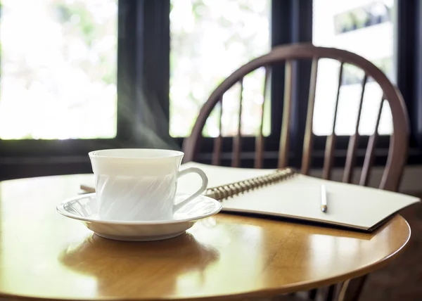 Taza de café con libro en la mesa en la cafetería — Foto de Stock
