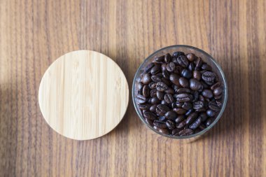 Kahve çekirdekleri cam ahşap arka plan üzerinde