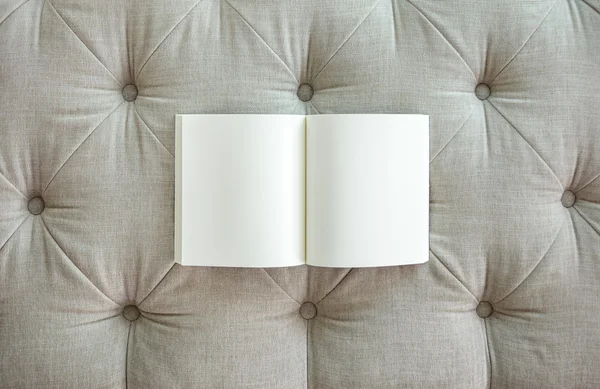 Boek met blanke pagina op sofa textuur — Stockfoto