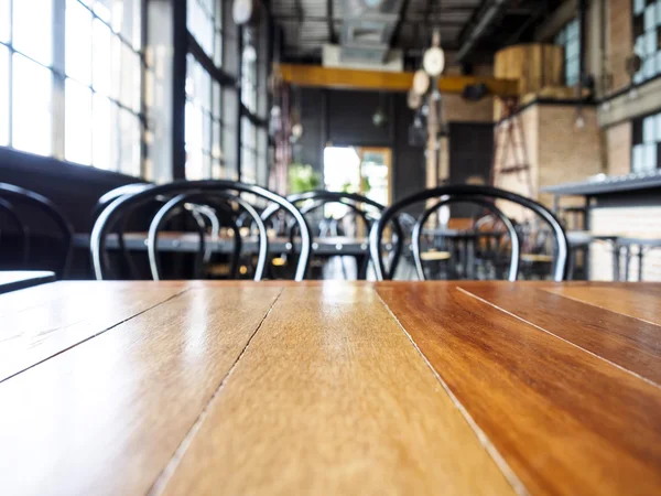 Parte superior de la mesa de madera y silla con fondo interior del restaurante —  Fotos de Stock