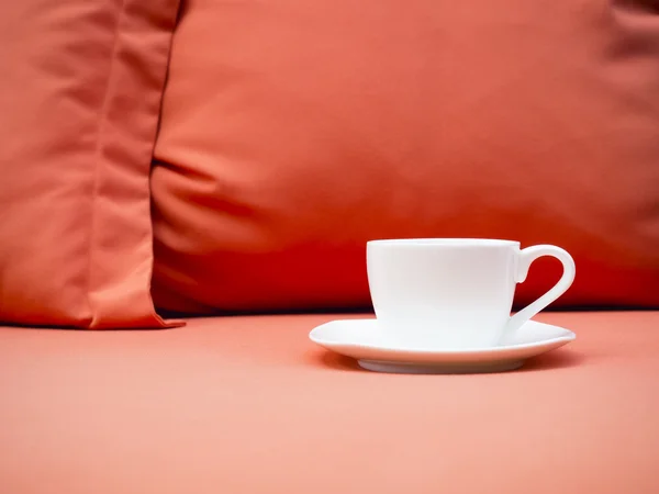 Šálek kávy na pohovce s polštářem — Stock fotografie