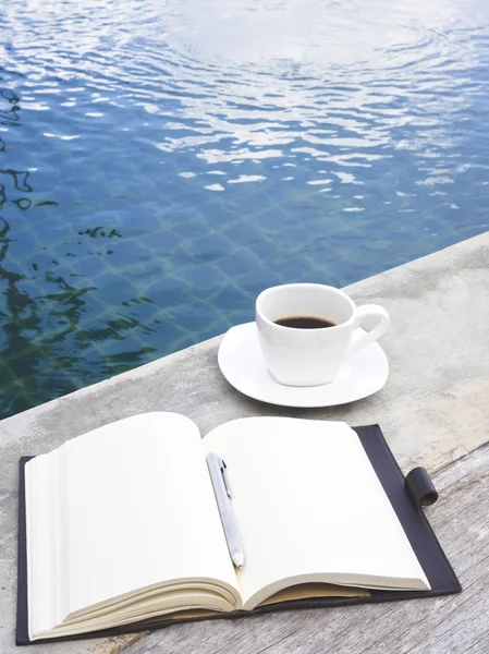 Café y libro con pluma en la piscina — Foto de Stock