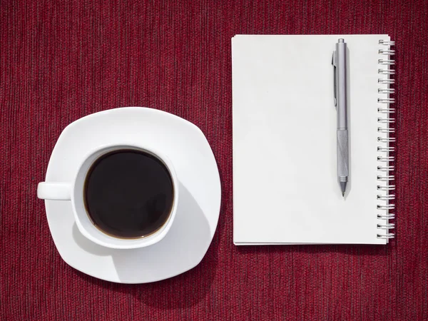 ノートとペンを赤いテーブル背景にコーヒー — ストック写真