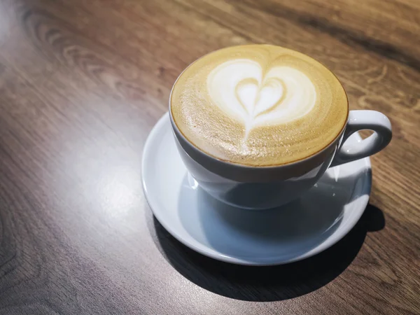 Tazza di caffè con schiuma di latte a forma di cuore vista dall'alto — Foto Stock