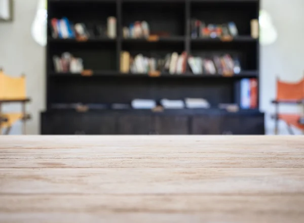 Piano del tavolo in legno con scaffale libro sfocato Sfondo interno — Foto Stock