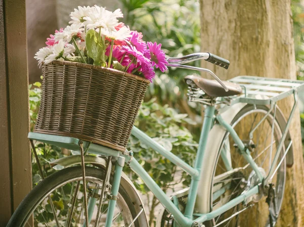 Vintage bicycle with flowers in basket — Stock Photo, Image