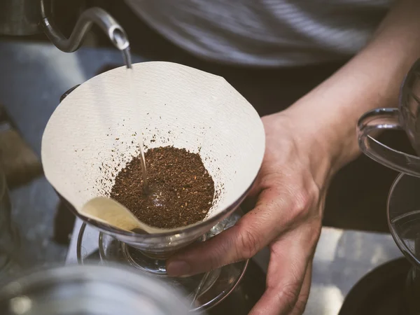 Main goutte à goutte café Barista verser de l'eau sur le café moulu — Photo