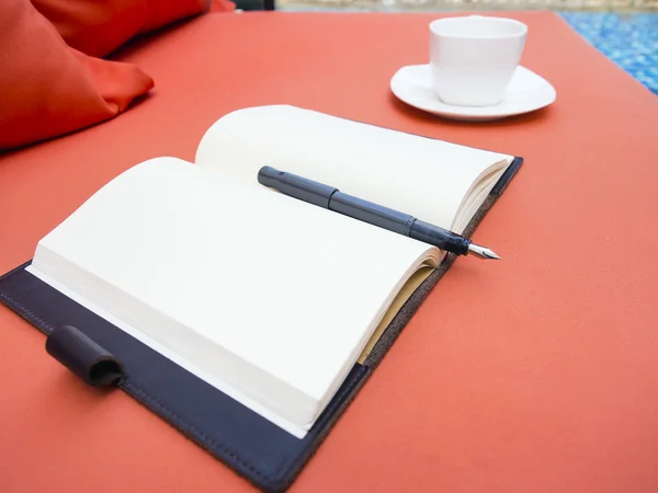 オープン空白ページの書籍のソファの上のコーヒー カップ — ストック写真