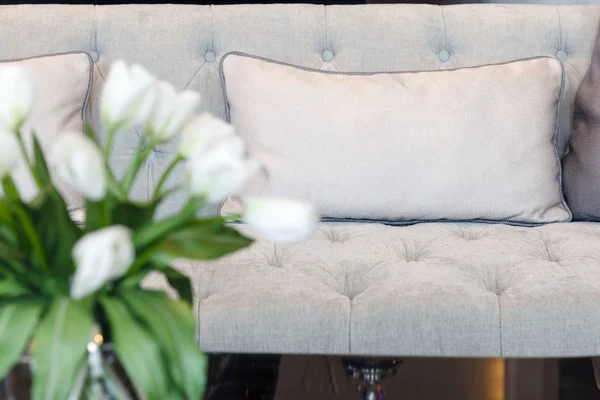 Καναπέ με μαξιλάρια ύφασμα και λουλούδι σπίτι εσωτερική διακόσμηση — Φωτογραφία Αρχείου