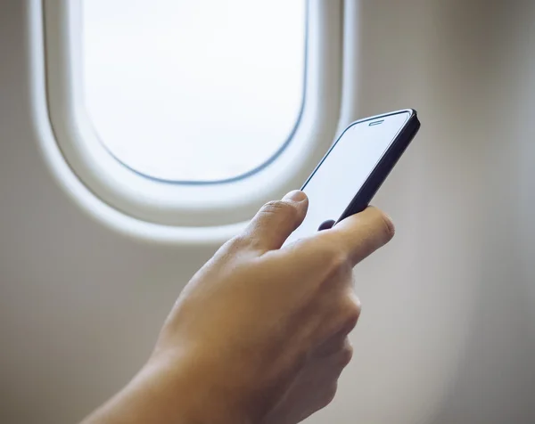 Kadın el cep telefonu uçağın içinde kullanma — Stok fotoğraf
