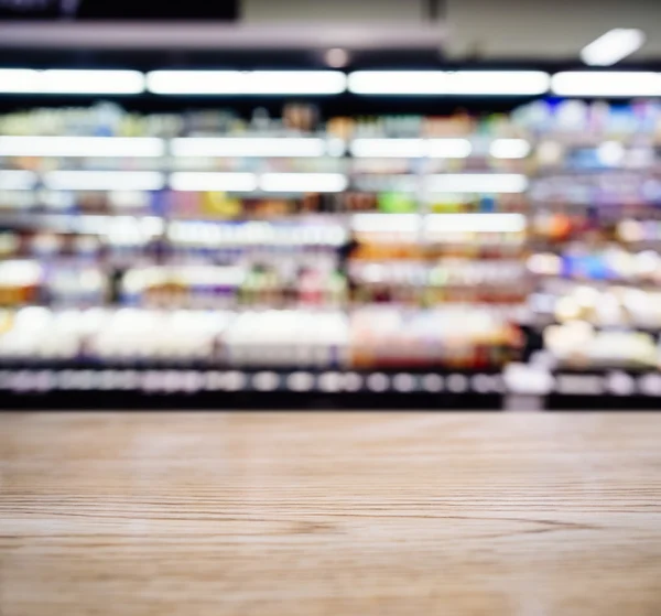 Tischtheke mit verschwommenem Supermarkt mit Produktregal — Stockfoto