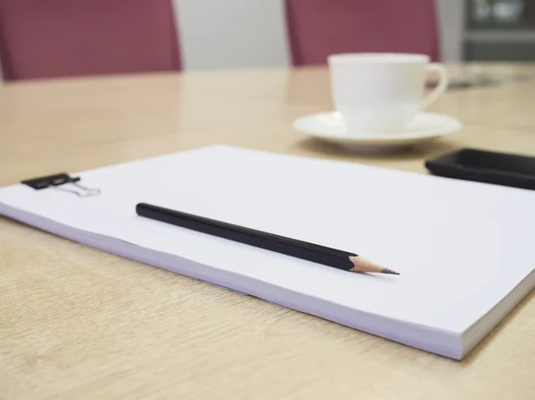 Бумага и карандаш с кофе и мобильным телефоном в конференц-зале — стоковое фото