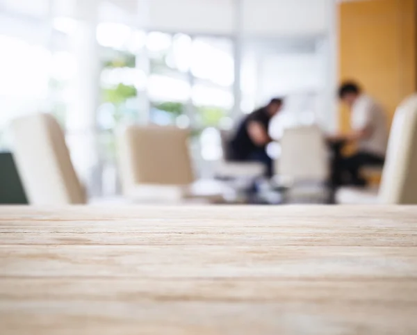 Tischplatte mit verschwommenen Personen im Lobbyinterieur — Stockfoto