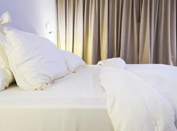 Cama de cama colchão e travesseiro bagunçado no quarto — Fotografia de Stock