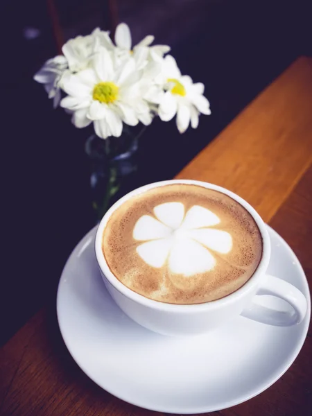 Tazza da caffè con decorazione di fiori margherita bianca su tavolo di legno — Foto Stock