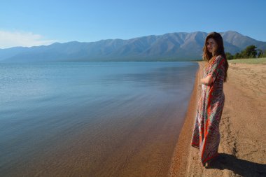 Uzun elbise ayakta kıyısında güzel, ince kız