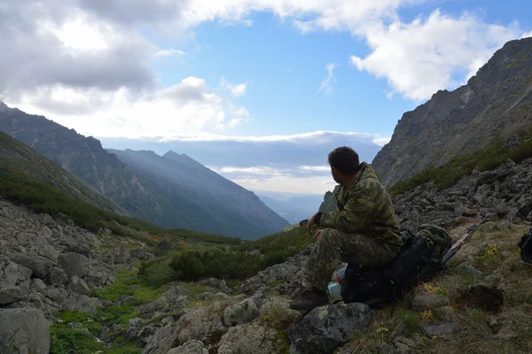 Мужской турист сидит в горах Баргузинского хребта на озере — стоковое фото