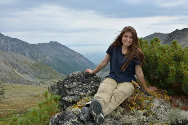 Gülümseyen kız turistik bir cl üstüne oturan bir av bıçağı ile