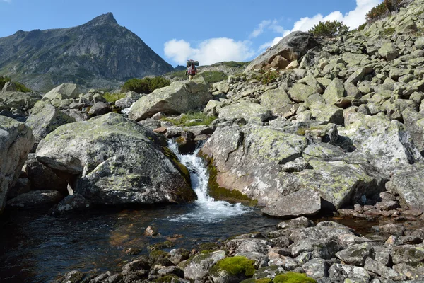 Los turistas caminan a lo largo de una llave en un valle de montaña cresta Barguzinsky — Foto de Stock