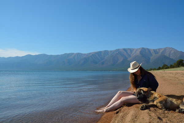Girl with a dog on the shore of Lake Baikal