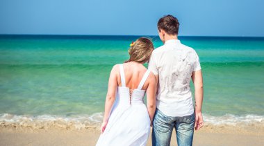 Seven çift tropikal bir plajda denize karşı
