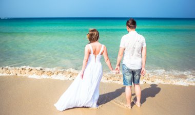 Seven çift tropikal bir plajda denize karşı