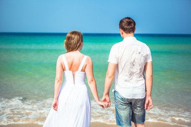 Seven çift tropikal bir plajda denize karşı