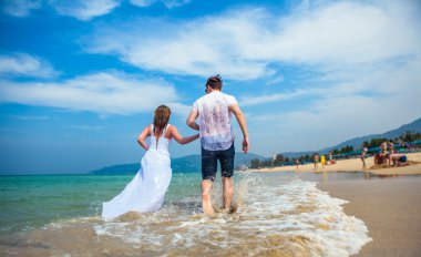 Seven çift tropikal bir plajda denize karşı