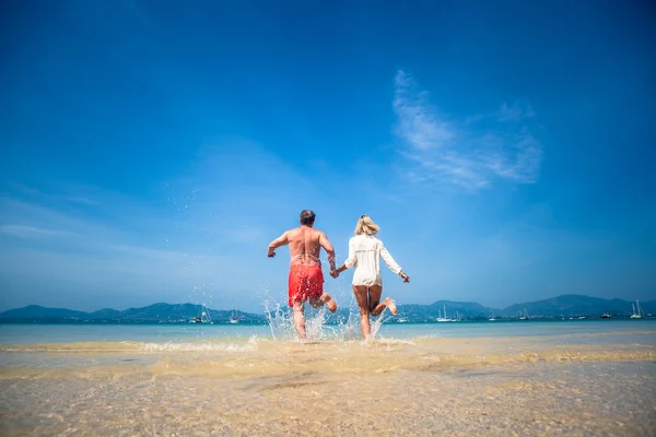 Älskande par på en tropisk strand mot havet — Stockfoto