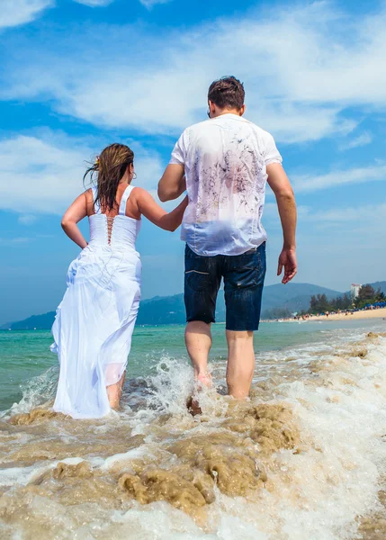 Älskande par på en tropisk strand mot havet — Stockfoto