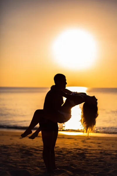 Happy Loving couple on a tropical beach hugging against the sea sunset — Stock Photo, Image