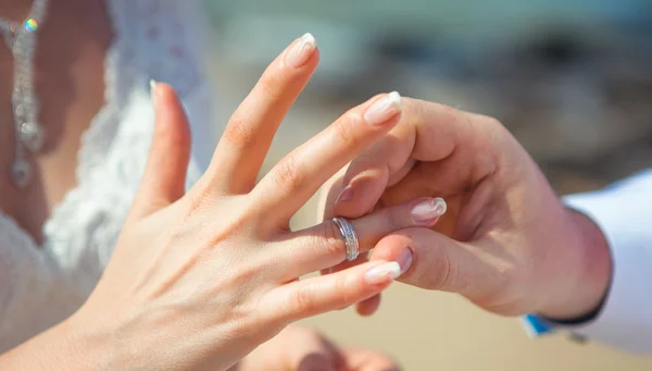 Um homem usa um casamento de mulher anel — Fotografia de Stock