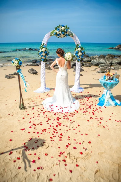 Ragazza in abito da sposa sullo sfondo di archi nuziali sul lungomare — Foto Stock