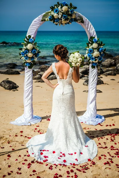 Bella ragazza felice in abito da sposa sullo sfondo di archi nuziali sul lungomare — Foto Stock