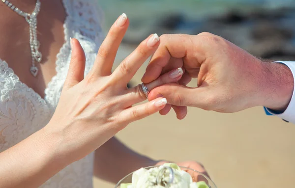 Um homem usa um casamento de mulher anel Imagem De Stock
